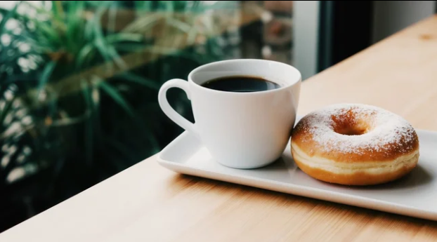 Un café servi avec un succulent donut du jour, fait maison !